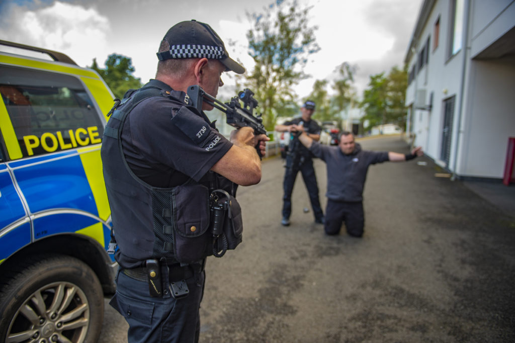 MDP Authorised Firearms Officer with firearm aimed at suspect in training scenario 